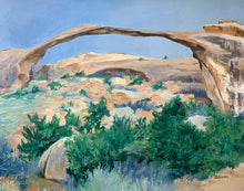 Load image into Gallery viewer, This original 11x14" oil painting captures the quiet strength of Landscape Arch under a soft blue sky, with lush scrub brush bringing unexpected life to the desert foreground. The warm stone, gentle light, and grounded atmosphere make it a beautiful statement piece for any home or collection.

